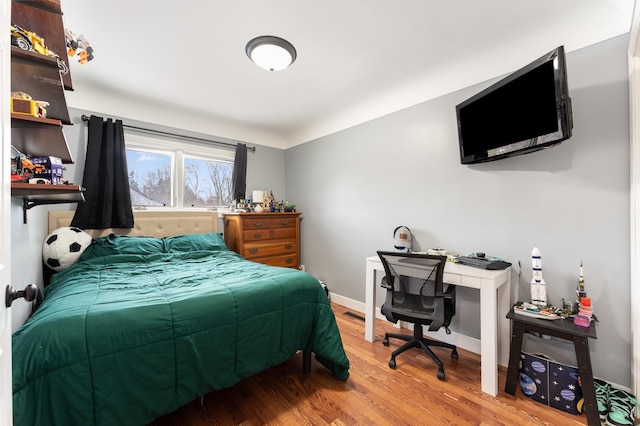 bedroom with wood finished floors and baseboards