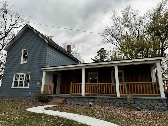 view of front of home featuring a porch and a chimney