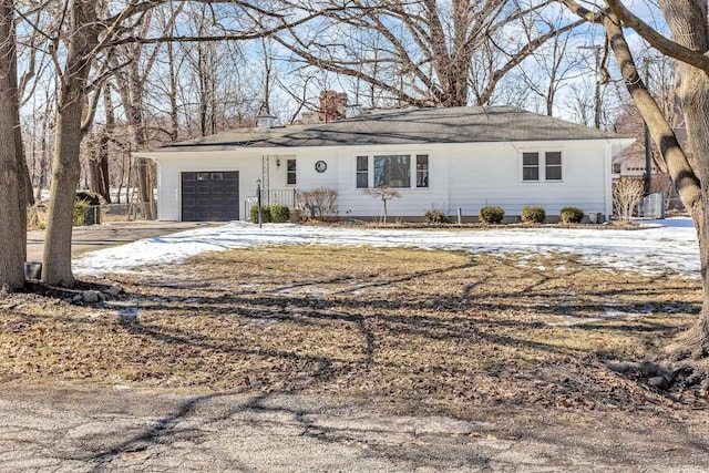 single story home with an attached garage, driveway, and a chimney