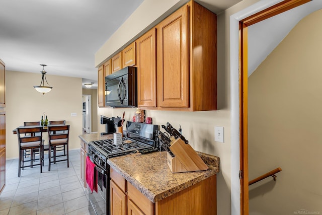 kitchen featuring black appliances, brown cabinetry, and light tile patterned flooring