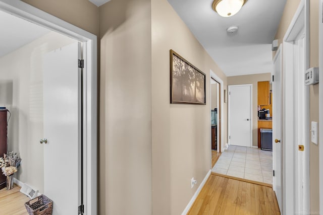 hallway featuring baseboards and light wood-style floors