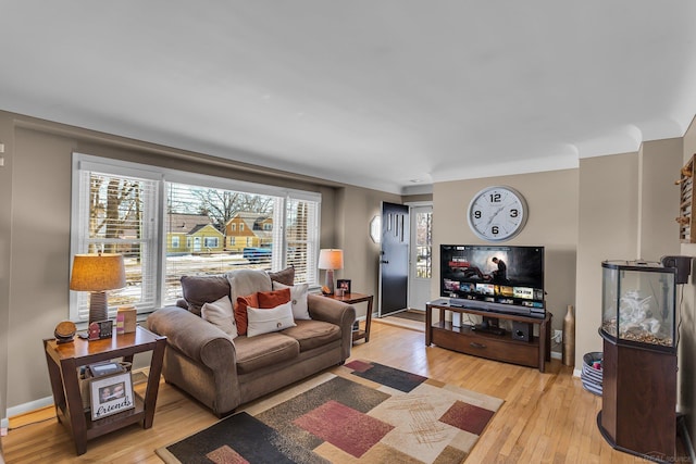 living room with baseboards and light wood-style floors