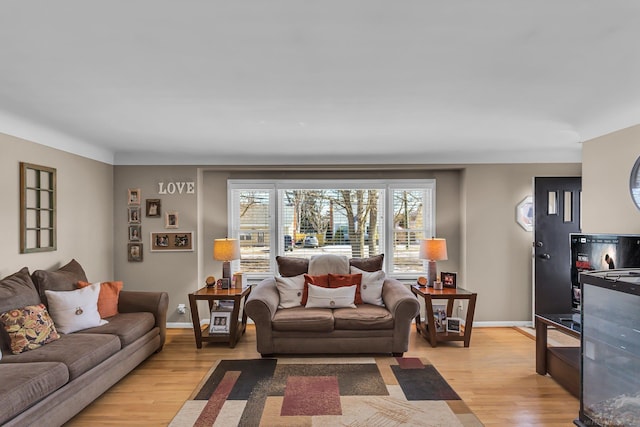 living area featuring light wood-style floors and baseboards