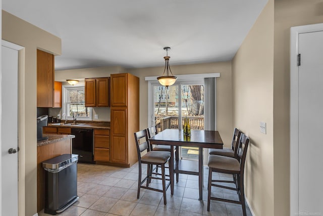 kitchen featuring dark countertops, plenty of natural light, black dishwasher, and brown cabinetry