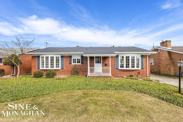 view of front of home featuring brick siding and a front yard