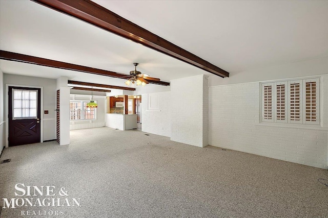 unfurnished living room featuring carpet floors, brick wall, ceiling fan, and beam ceiling