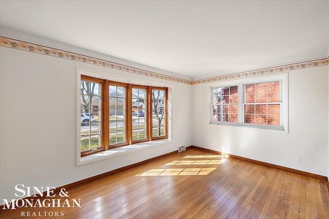 empty room with hardwood / wood-style flooring and baseboards