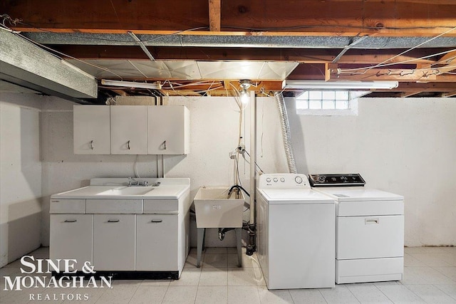 washroom with independent washer and dryer, a sink, and cabinet space