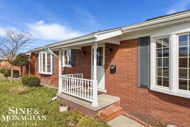 view of exterior entry with brick siding