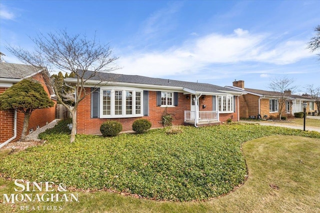 ranch-style house with brick siding and a front yard