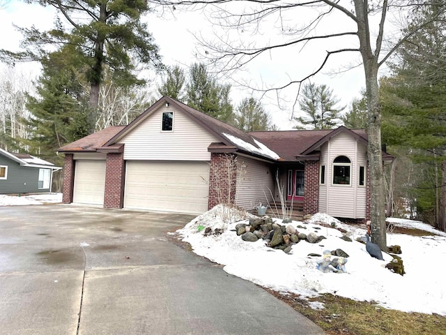 ranch-style home with driveway, brick siding, and an attached garage