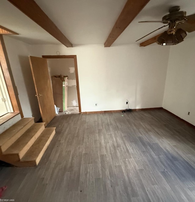 spare room with ceiling fan, baseboards, beamed ceiling, and wood finished floors