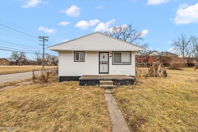 bungalow-style house featuring fence and a front lawn