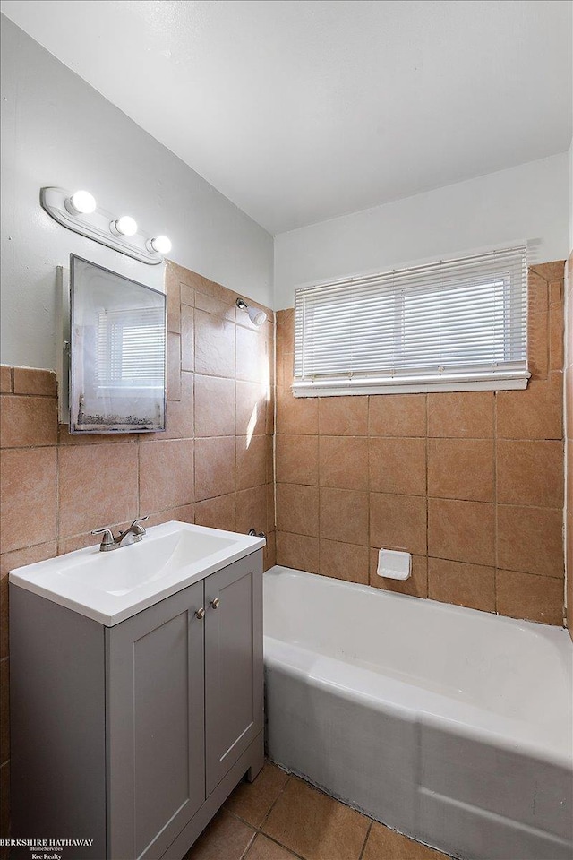 bathroom featuring a healthy amount of sunlight, tile walls, vanity, and tile patterned floors