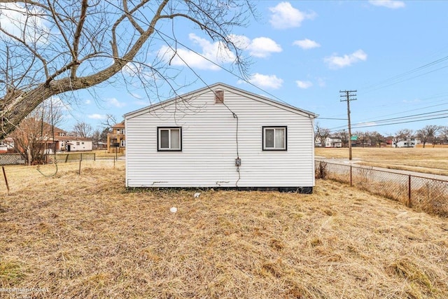 view of property exterior featuring fence and a yard