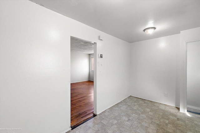 unfurnished room featuring a textured ceiling and tile patterned floors