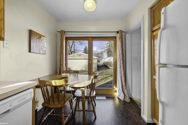 dining room with baseboards, visible vents, and dark wood-style flooring