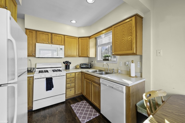 kitchen featuring light countertops, white appliances, dark wood-style flooring, and a sink