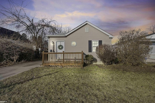 view of front facade with a deck and a front lawn