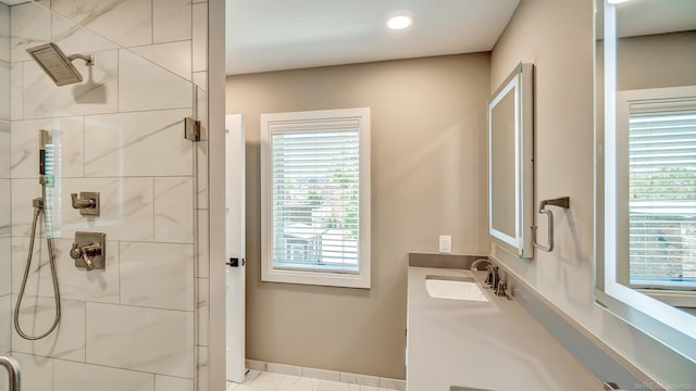 bathroom with a stall shower, baseboards, a wealth of natural light, and vanity