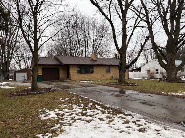 single story home with a garage, driveway, and a chimney