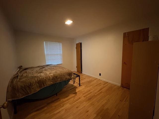 bedroom with light wood-style flooring and baseboards