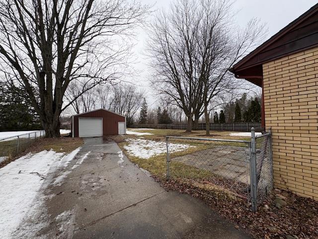 view of yard with an outbuilding, a detached garage, and fence