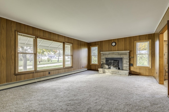 unfurnished living room featuring wood walls, carpet, a fireplace, and baseboard heating