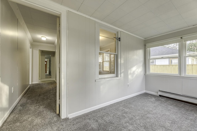 spare room with baseboards, carpet, a baseboard heating unit, and crown molding