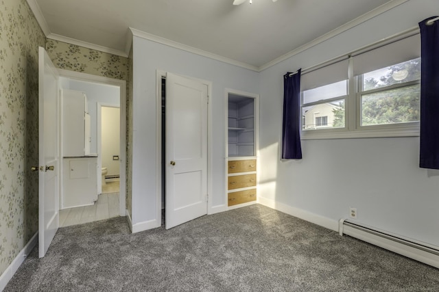 unfurnished bedroom featuring a baseboard heating unit, ornamental molding, carpet floors, and baseboards