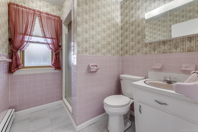 bathroom featuring toilet, baseboard heating, a stall shower, wainscoting, and wallpapered walls