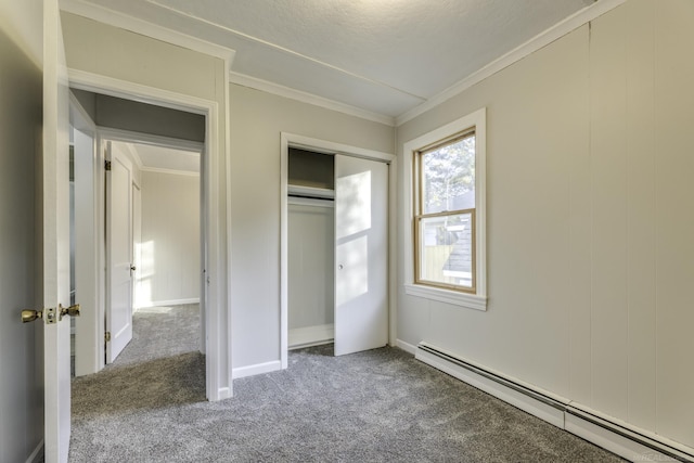 unfurnished bedroom featuring a baseboard heating unit, carpet floors, baseboards, ornamental molding, and a closet