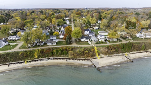 drone / aerial view with a residential view, a water view, and a wooded view