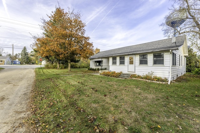 single story home featuring entry steps and a front lawn