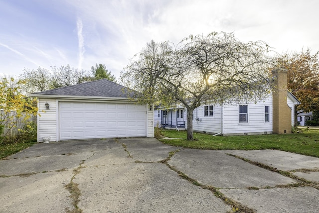 view of front of house featuring a garage, a chimney, roof with shingles, an outbuilding, and a front lawn