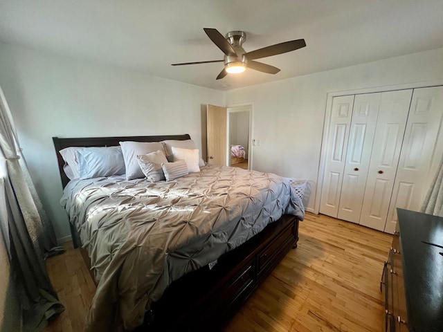 bedroom featuring light wood finished floors, baseboards, a ceiling fan, and a closet