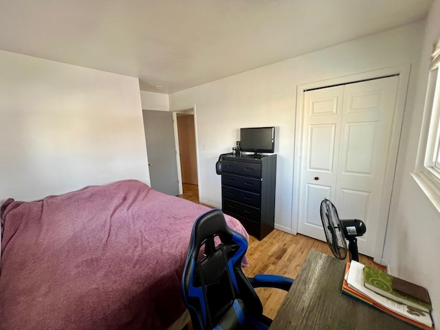 bedroom with light wood-style floors and a closet