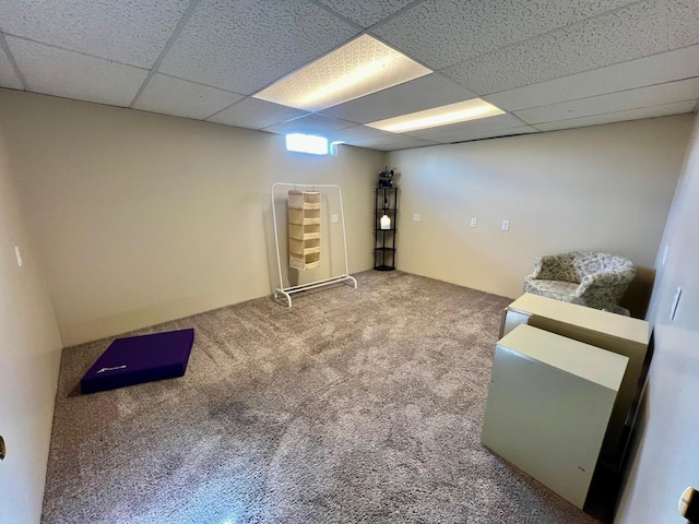 finished basement featuring carpet flooring and a paneled ceiling