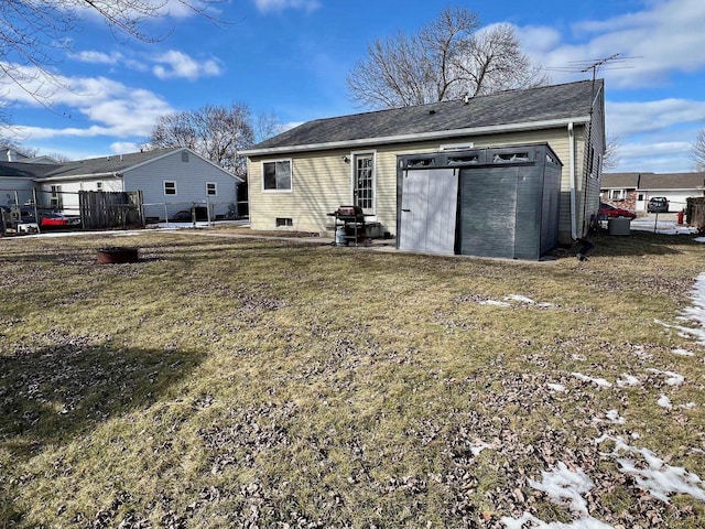 back of property featuring a lawn and fence