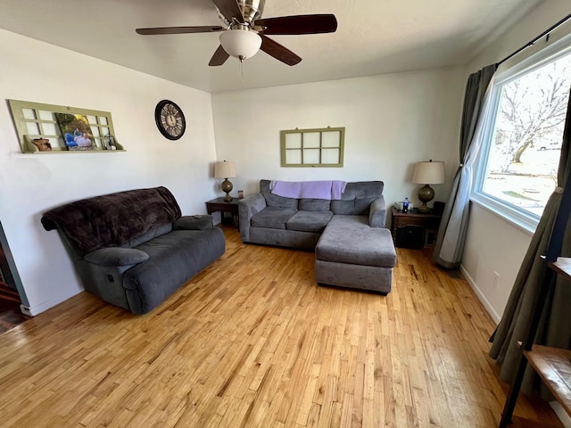 living room featuring a ceiling fan, light wood-style flooring, and baseboards