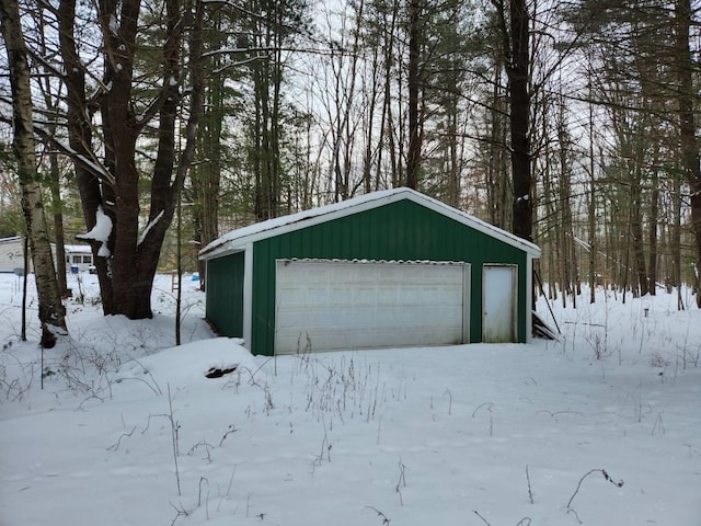 snow covered garage with a garage