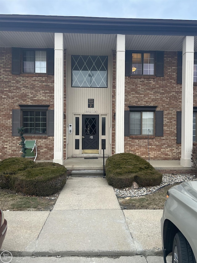 doorway to property with brick siding