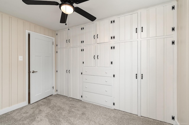 unfurnished bedroom featuring a ceiling fan, a closet, and light colored carpet