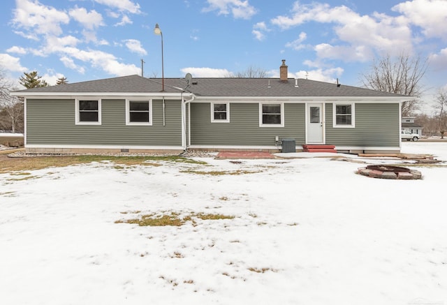 snow covered rear of property featuring entry steps and cooling unit