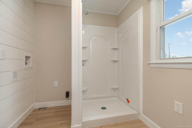 bathroom with a stall shower, baseboards, and wood finished floors