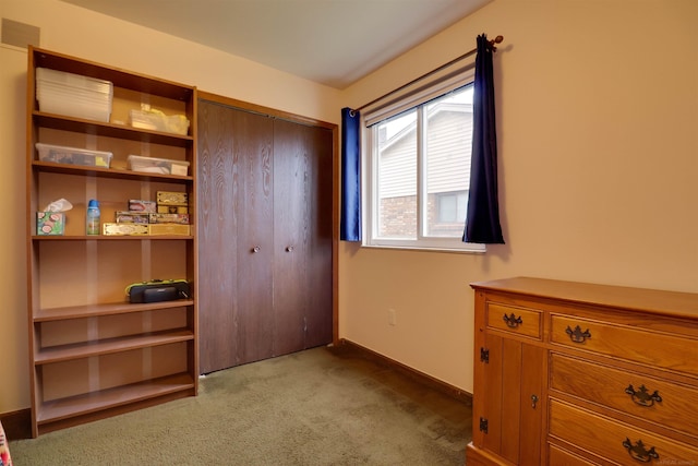 bedroom with a closet, visible vents, light carpet, and baseboards