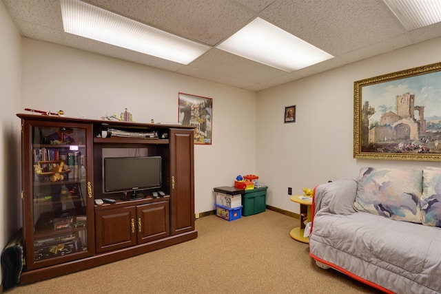 living room with baseboards, light carpet, and a drop ceiling