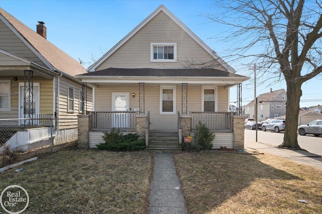 bungalow-style house featuring a porch, a front yard, and fence