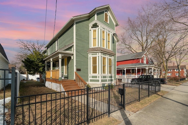 view of front of property featuring covered porch and a fenced front yard