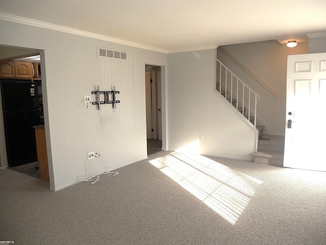 empty room with carpet floors, stairway, visible vents, and crown molding